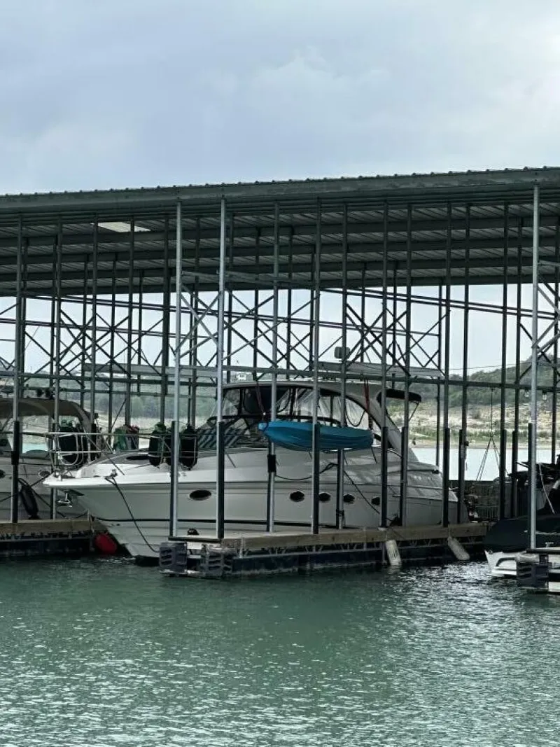 Slide: The Image of A 2007 Regal Commodore 4460 docked in a covered marina area on the water. - 2