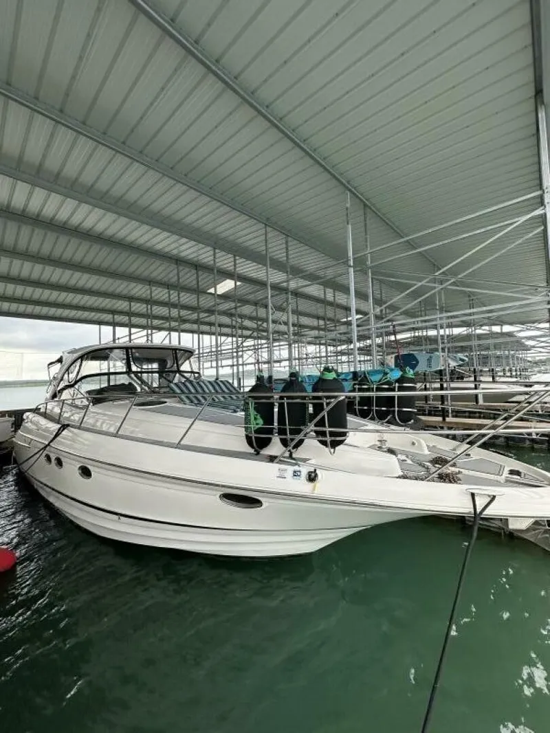 The Image of A white 2007 Regal Commodore 4460 is docked in a covered marina. - 0