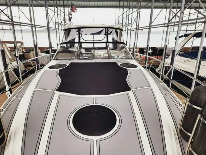 Slide: The Image of The 2007 Regal Commodore 4460 is docked under a covered area. The deck is sleek and modern. - 3