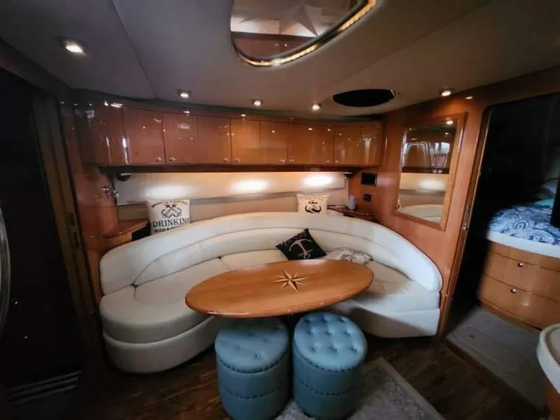 Slide: The Image of The interior cabin of a 2007 Regal Commodore 4460 features an elegant seating area with a wooden table and cushioned stools. - 7