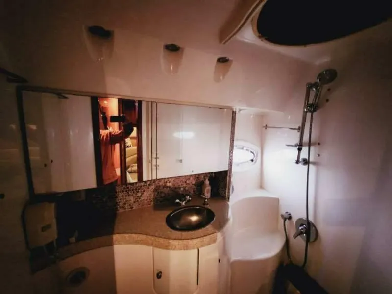 Slide: The Image of The image shows a boat bathroom with a sink, mirror, and shower. - 13