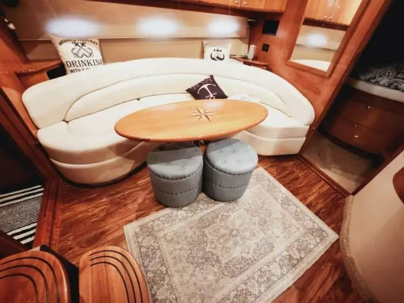 Slide: The Image of The interior cabin of a 2007 Regal Commodore 4460 features an elegant sofa, wooden table, and stools. - 15