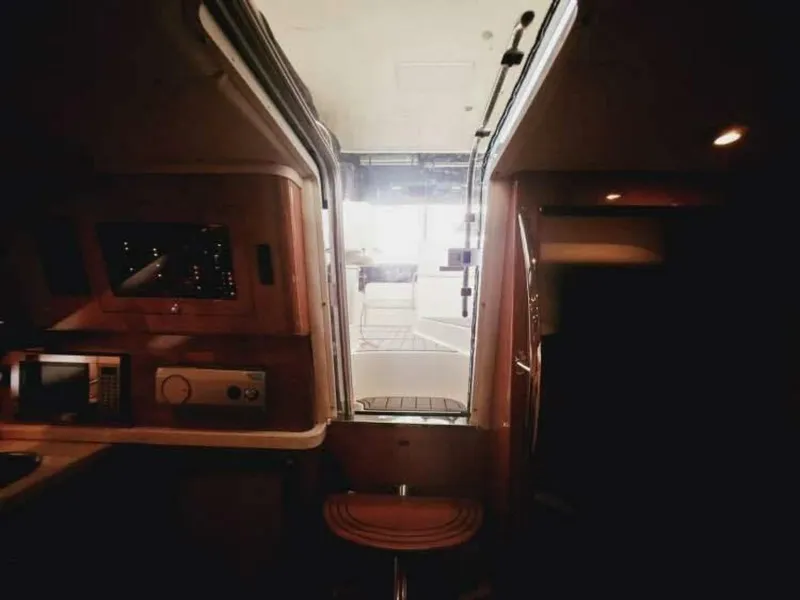 Slide: The Image of Interior view of a 2007 Regal Commodore 4460, featuring a cabin with wood furnishings and a passage to the deck. - 11