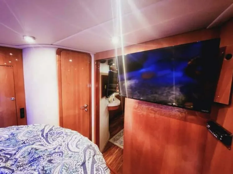 Slide: The Image of The cabin of a 2007 Regal Commodore 4460 with a large TV and wooden walls. - 14