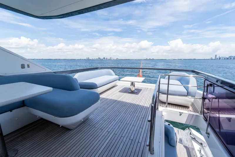 Slide: The Image of Luxurious 2023 Azimut Fly 68 yacht deck with modern seating, overlooking serene ocean and city skyline. - 20