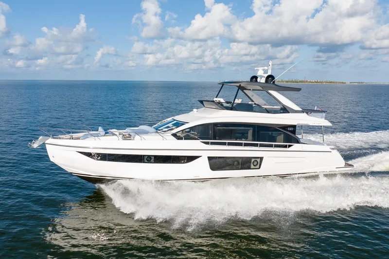 The Image of 2023 Azimut Fly 68 yacht cruising on open water under a clear blue sky. - 1