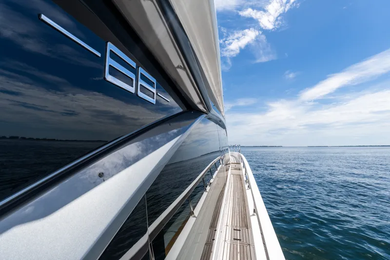 Slide: The Image of 2023 Azimut Fly 68 yacht cruising on open water under a clear blue sky. - 73