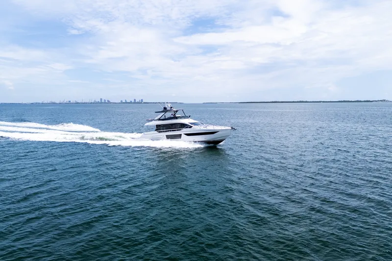 Slide: The Image of 2023 Azimut Fly 68 yacht cruising on open water under a clear blue sky. - 112