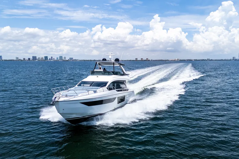 Slide: The Image of 2023 Azimut Fly 68 yacht cruising on open water under a clear blue sky. - 10