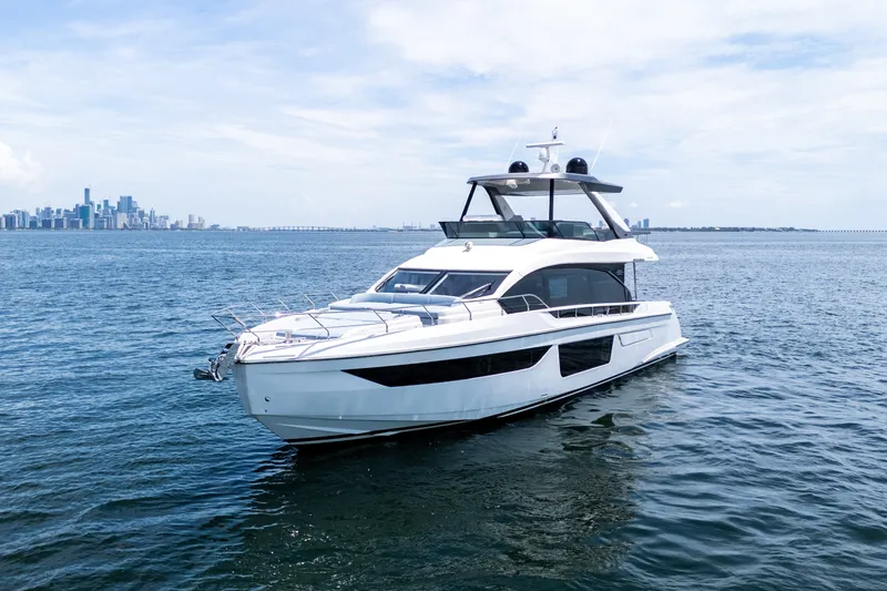 Slide: The Image of 2023 Azimut Fly 68 yacht cruising on open water with city skyline in background. - 83