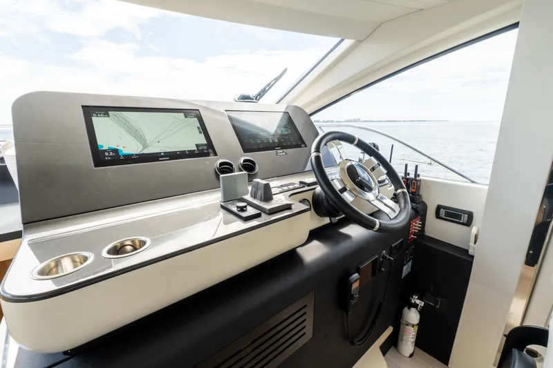 Slide: The Image of 2023 Azimut Fly 68 yacht helm with modern navigation displays and steering wheel. - 59