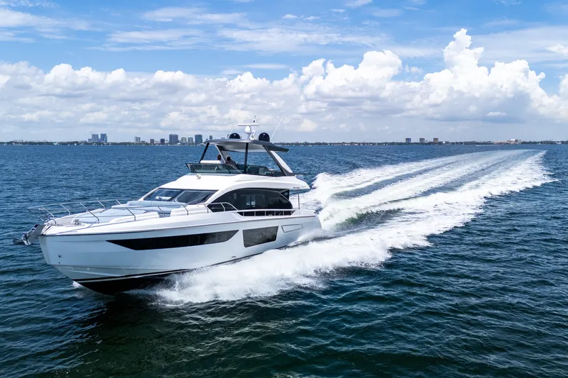 Slide: The Image of 2023 Azimut Fly 68 yacht cruising on open water under a clear blue sky. - 9