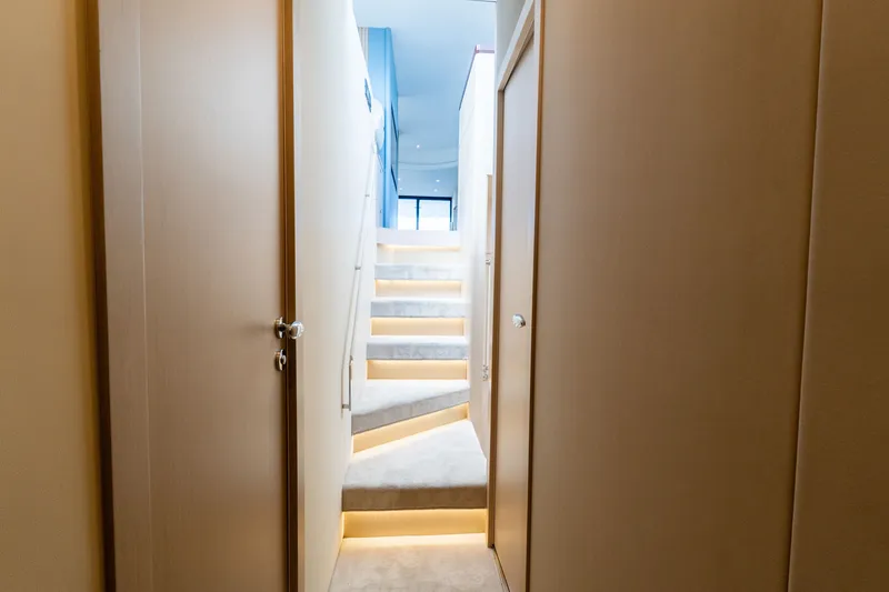Slide: The Image of Interior view of 2023 Azimut Fly 68 yacht, featuring illuminated staircase and modern design. - 46