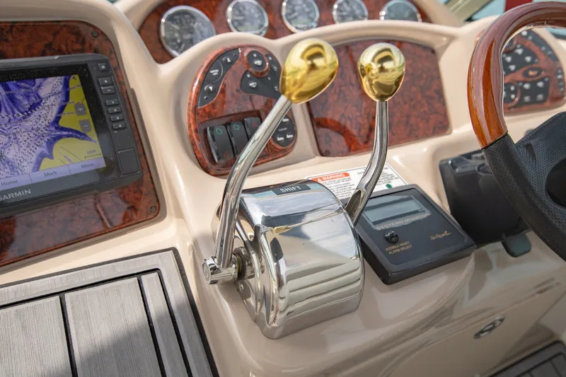 Slide: The Image of Dashboard of a 2004 Sea Ray 340 Sundancer with navigation and control levers. - 25