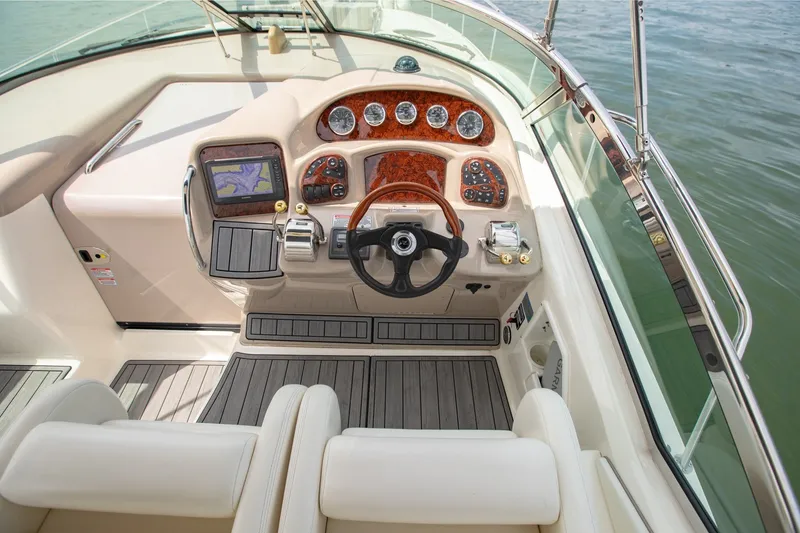 Slide: The Image of Cockpit of 2004 Sea Ray 340 Sundancer with steering wheel and navigation controls. - 23