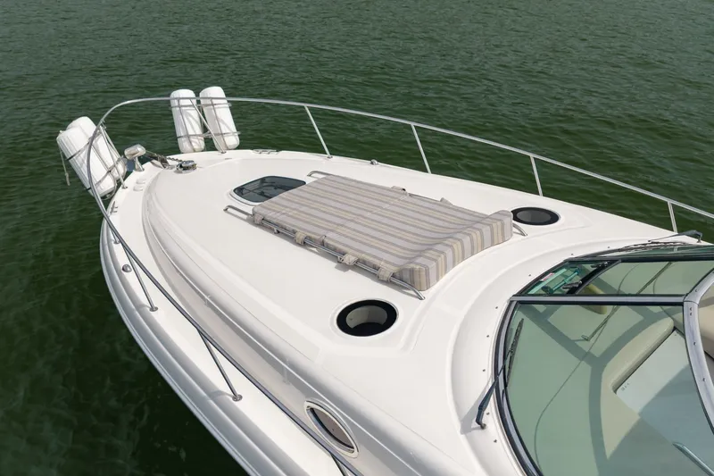 Slide: The Image of 2004 Sea Ray 340 Sundancer boat with sunpad on deck, floating on calm water. - 9