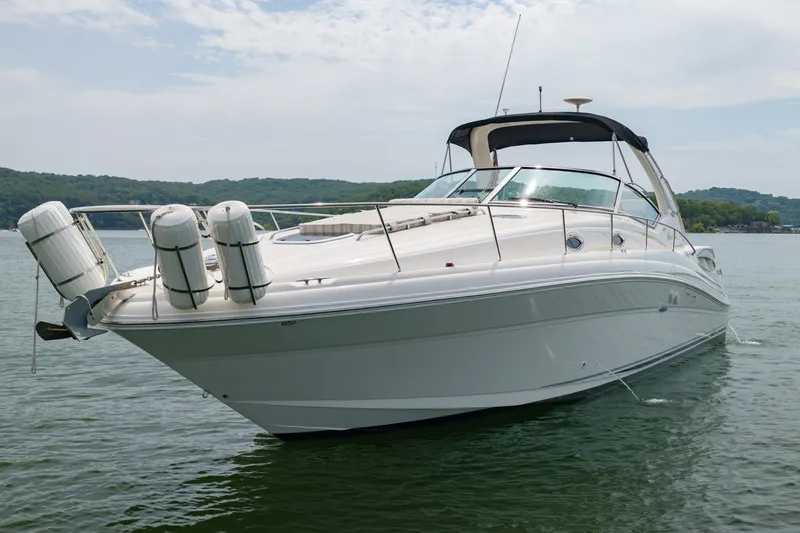 Slide: The Image of 2004 Sea Ray 340 Sundancer yacht on calm water, scenic background. - 12