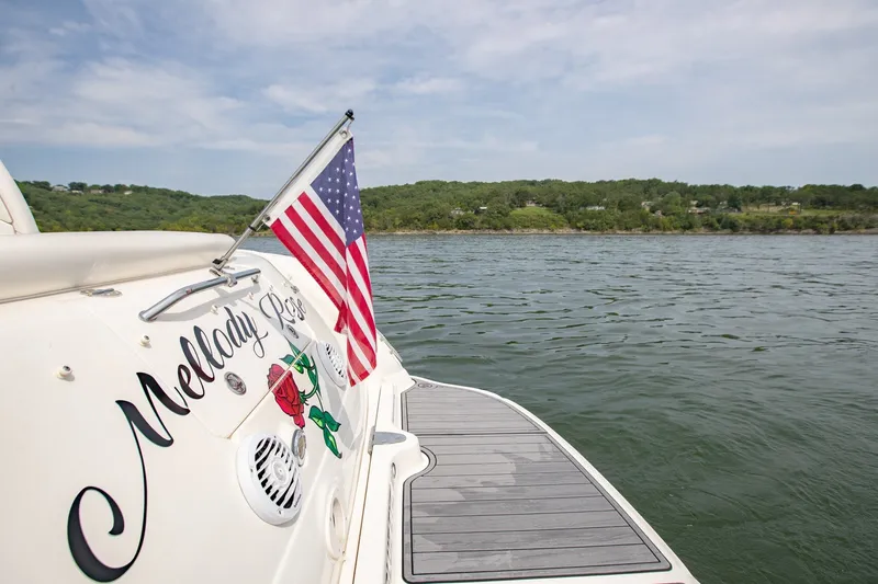 Slide: The Image of 2004 Sea Ray 340 Sundancer with American flag on lake, scenic view in background. - 14