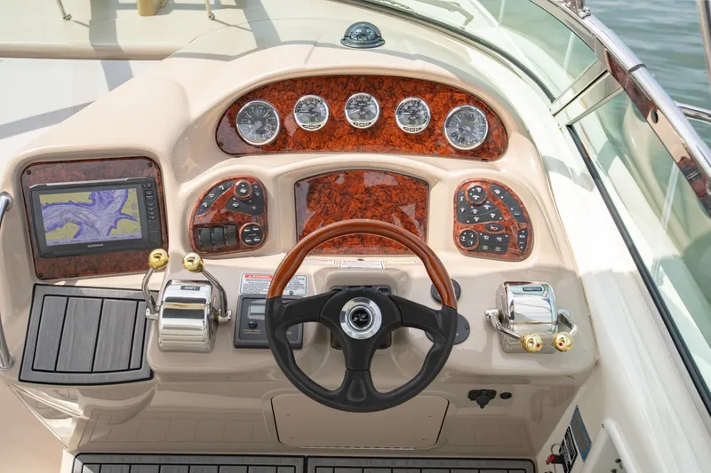 Slide: The Image of 2004 Sea Ray 340 Sundancer helm with wood accents, gauges, and navigation system. - 24