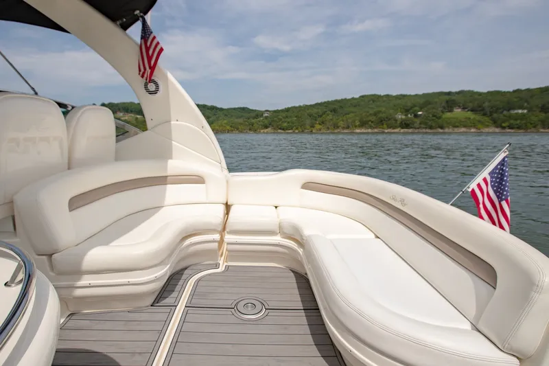 Slide: The Image of 2004 Sea Ray 340 Sundancer boat interior with white seating, American flags, and scenic water view. - 17