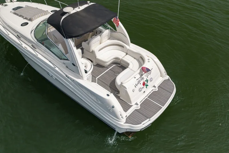 Slide: The Image of 2004 Sea Ray 340 Sundancer yacht with spacious deck, cruising on calm green waters. - 10
