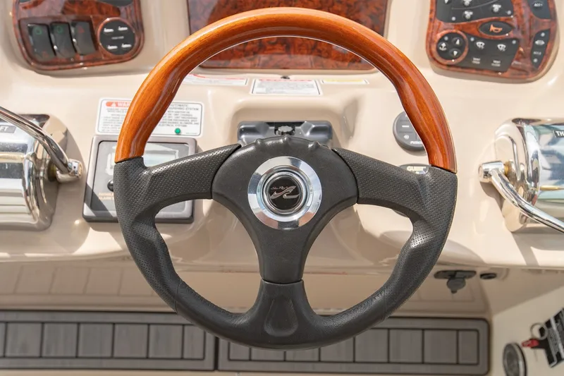 Slide: The Image of Steering wheel of a 2004 Sea Ray 340 Sundancer boat, featuring wood and leather accents. - 30