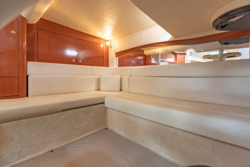 Slide: The Image of Interior of 2004 Sea Ray 340 Sundancer yacht with plush seating and wooden cabinetry. - 32