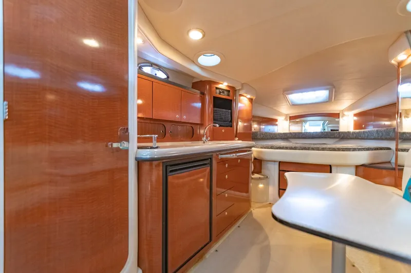 Slide: The Image of Luxurious interior of 2004 Sea Ray 340 Sundancer yacht with modern kitchen and seating area. - 34