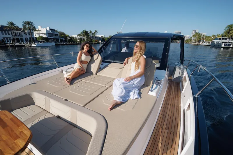 Slide: The Image of Women relaxing on a luxurious 2026 Hanover 447 yacht, cruising along a scenic waterfront. - 23