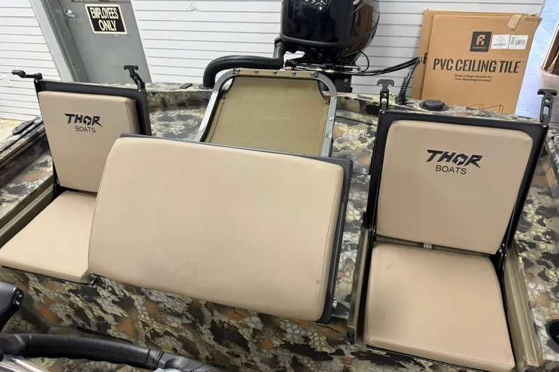 Slide: The Image of Interior of a 2027 Thor BH1900CC boat with beige seats and camo design. - 12