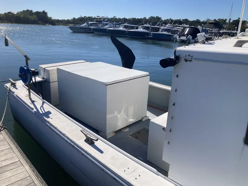Slide: The Image of A white boat with a large rectangular structure at the stern is docked. Other boats are visible in the background. - 14
