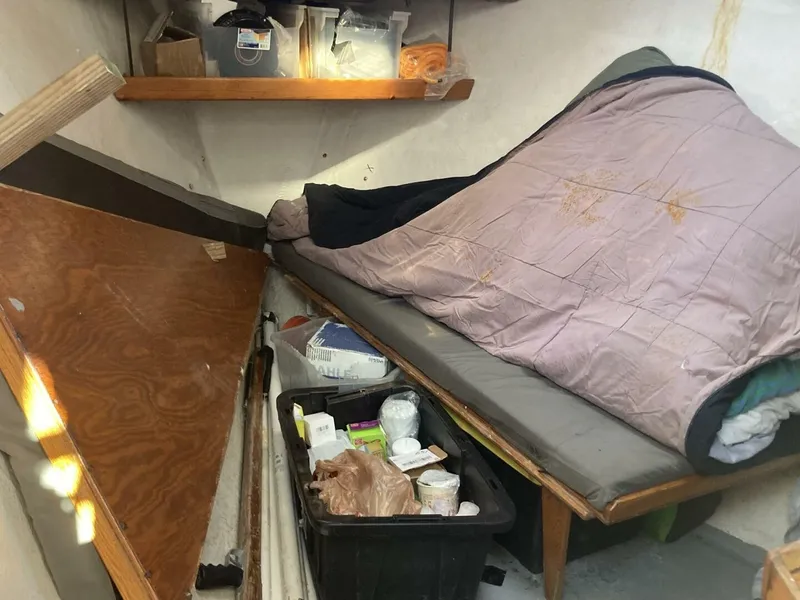 Slide: The Image of Interior of a 1986 BHM 32 with a sleeping area and storage. - 18