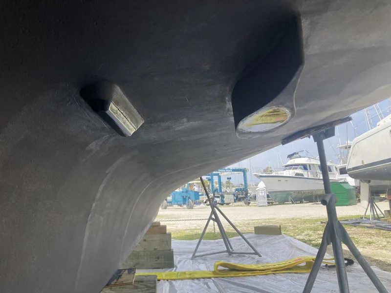 Slide: The Image of Underside of a boat with supports and equipment in a boatyard setting. - 31