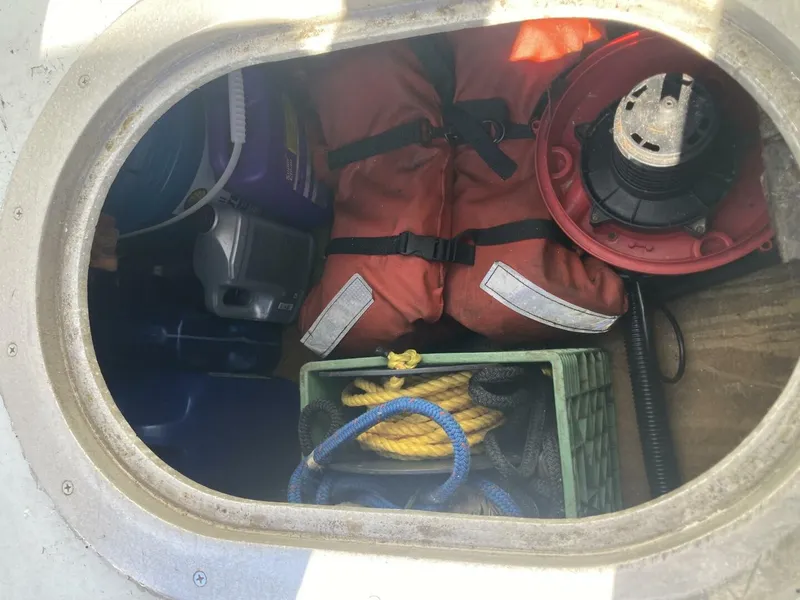 Slide: The Image of A storage compartment with life jackets, ropes, and other boating accessories. - 9