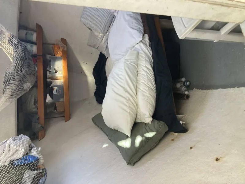 Slide: The Image of A cozy sleeping area with pillows and blankets inside a boat. - 22