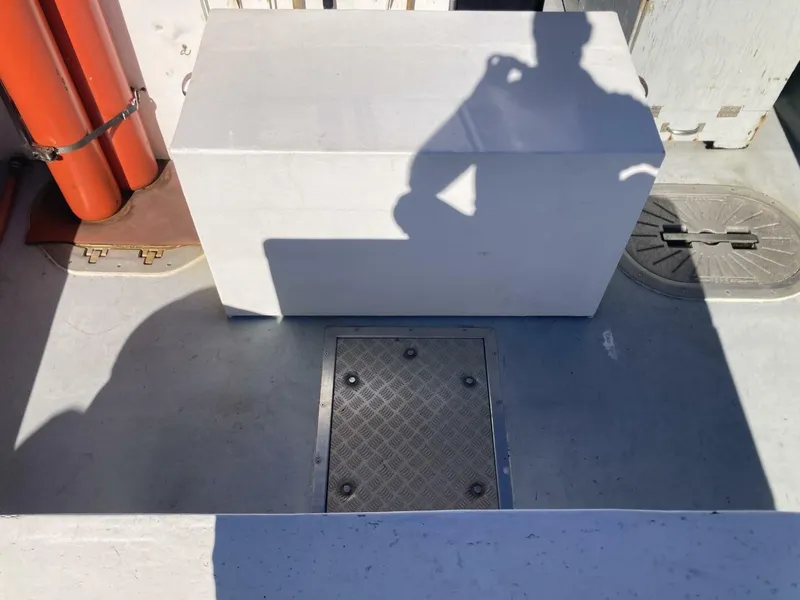 Slide: The Image of The image shows a boat deck with a white box and a metal access panel. - 10