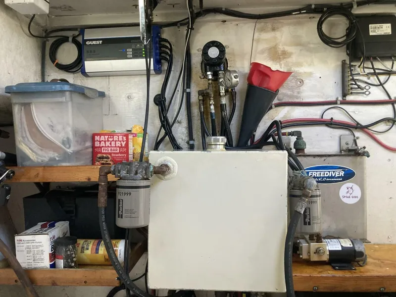 Slide: The Image of An engine room with various equipment, hoses, and a white tank. Tools and accessories are visible. - 19