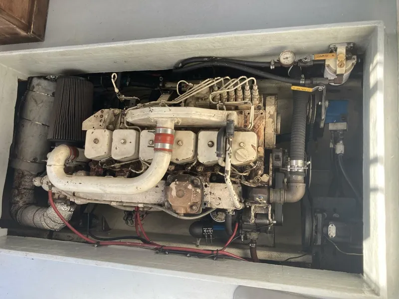 Slide: The Image of An engine compartment with a large diesel engine, hoses, and wiring. - 12