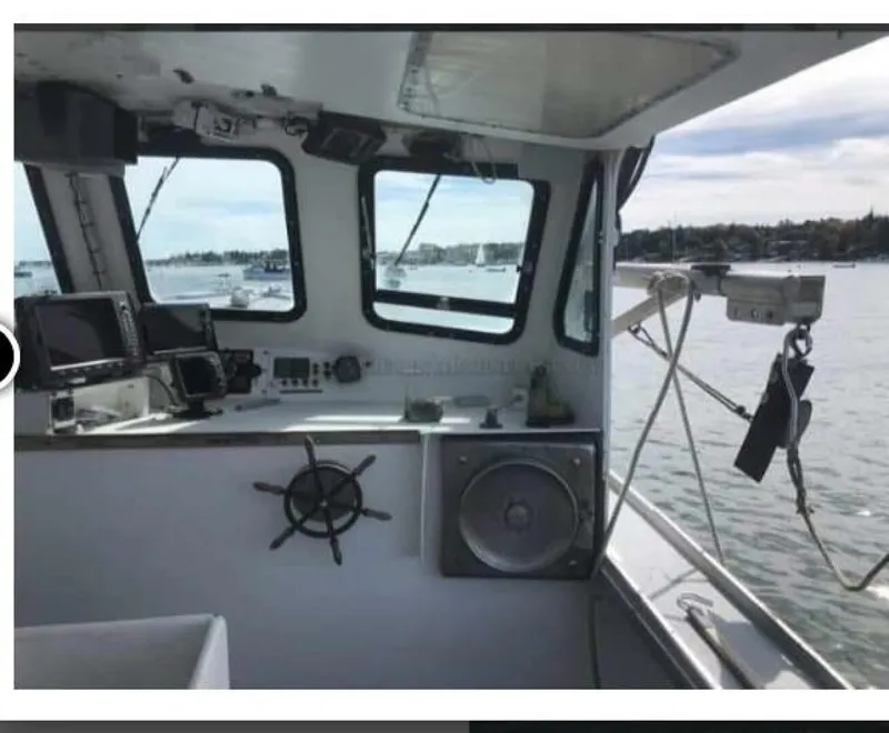 Slide: The Image of The image shows the helm of a 1986 BHM 32 boat with a view of the harbor. - 5