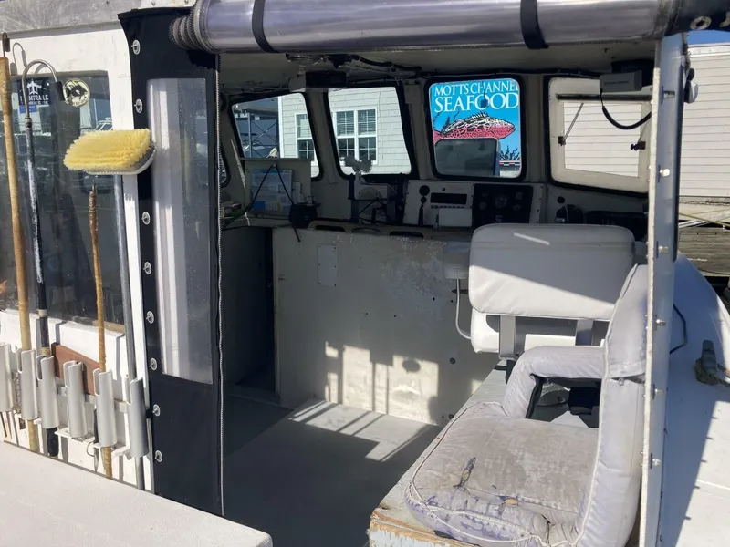 Slide: The Image of The image shows the cockpit of a 1986 BHM 32 boat with seating and a helm console. - 24