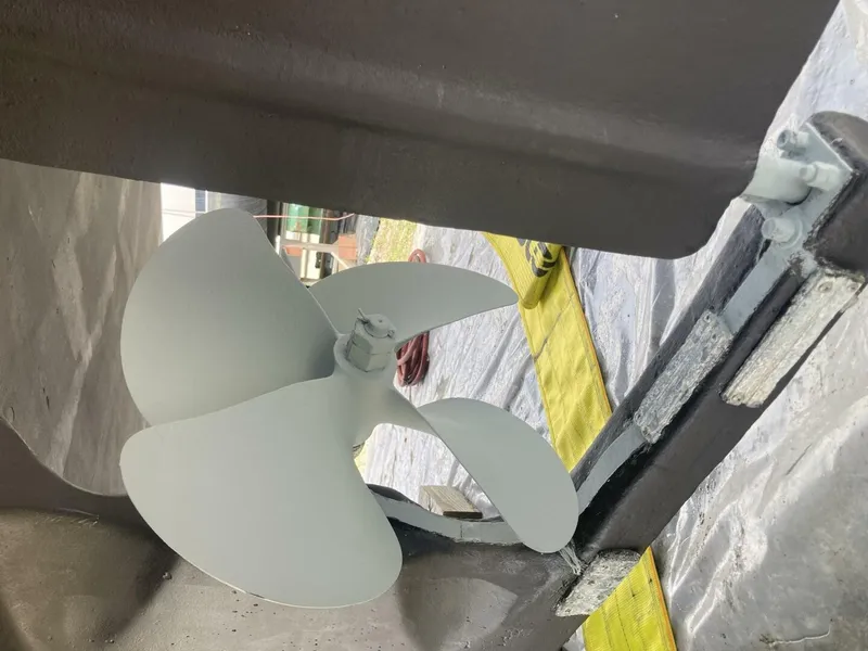 Slide: The Image of Close-up of a boat propeller under a 1986 BHM 32, in a dry dock setting. - 41