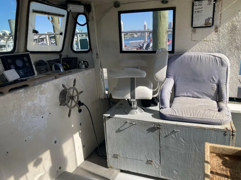 Slide: The Image of The image shows the helm of a 1986 BHM 32 boat with two seats and a steering wheel. - 25