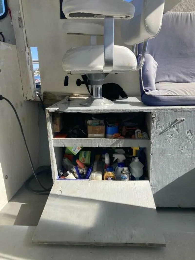 Slide: The Image of A boat chair above an open storage compartment with cleaning supplies and tools. - 26