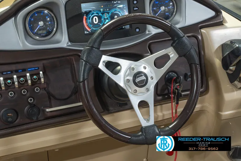 Slide: The Image of Steering wheel and dashboard of 2017 South Bay 725 RS boat, featuring modern gauges and controls. - 36