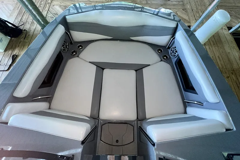 Slide: The Image of 2023 Axis A225 boat interior with gray cushioned seating and cup holders. - 22