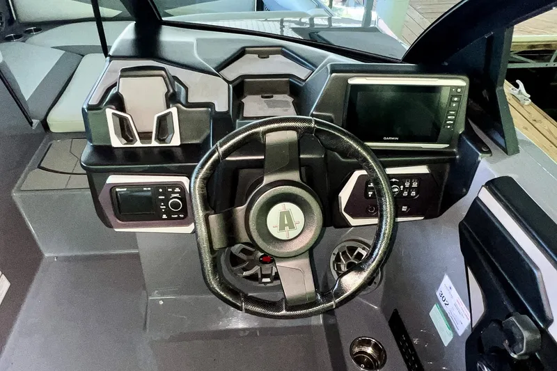Slide: The Image of 2023 Axis A225 boat dashboard with steering wheel and Garmin display. - 16