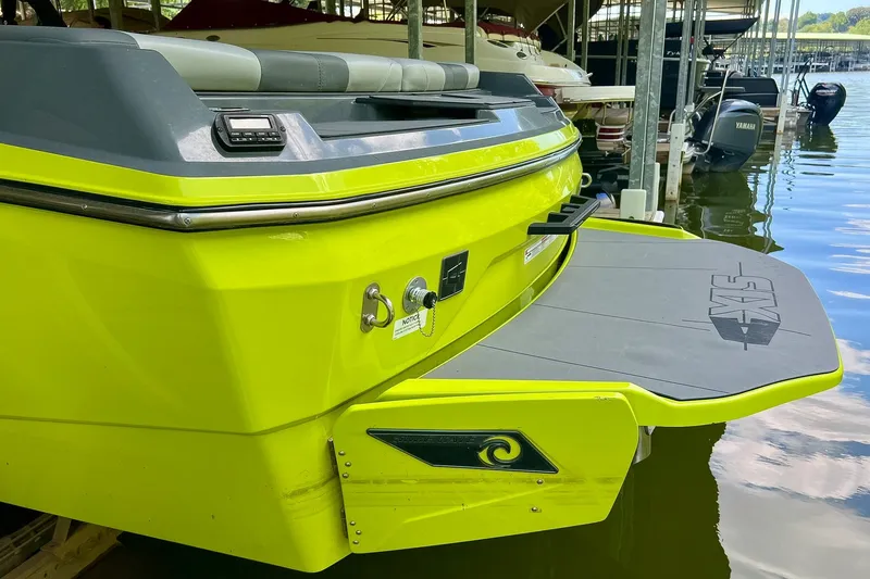 Slide: The Image of 2023 Axis A225 boat with vibrant yellow exterior, docked at a marina. - 4