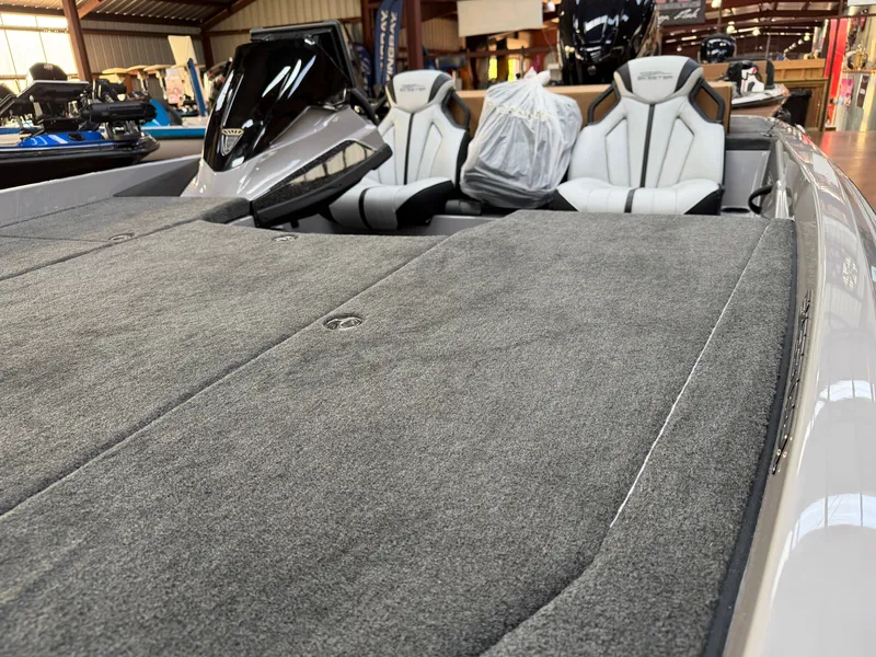 Slide: The Image of The image shows the deck of a 2027 Skeeter ZXE20 boat with gray carpeting and two seats. - 9