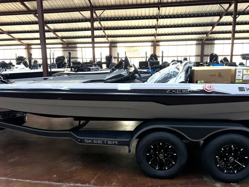 Slide: The Image of Skeeter ZXE20 2027 in a warehouse, on a trailer with black wheels. - 3
