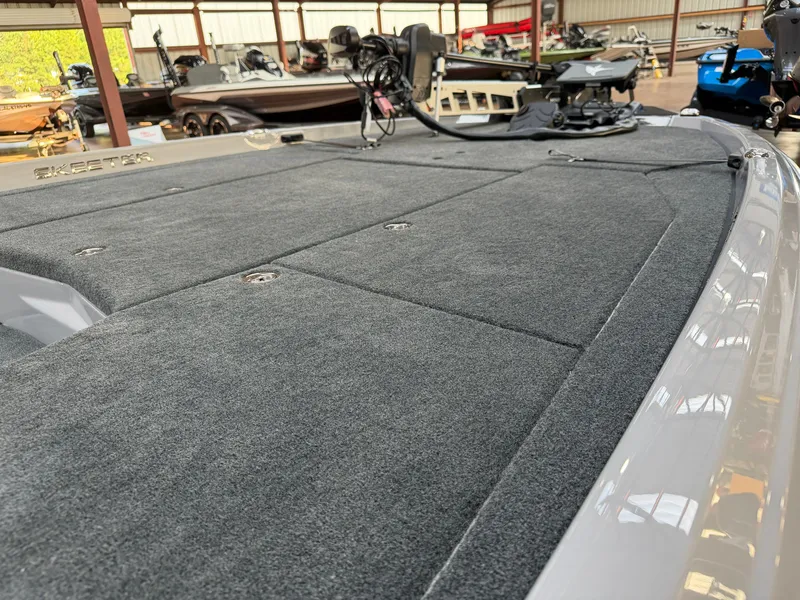 Slide: The Image of The image shows the deck of a 2027 Skeeter ZXE20 boat with gray carpeting. - 5